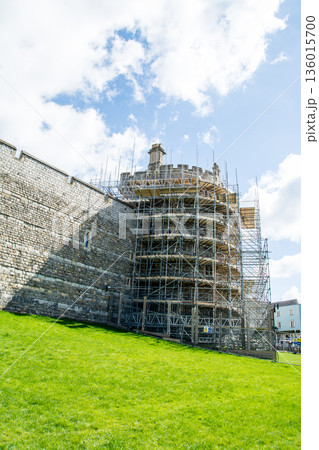 明るい青空と浮かぶ雲の下の工事のための足場が組まれ歴史的な石造りのウィンザー城　ロンドン郊外の街並み 136015700