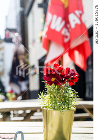 明るい日差しの下の店先に置かれたテーブルの上の真っ赤なかわいい花 ロンドン郊外のウィンザーの街並み 明るい日差しの下の店先に置かれたテーブルの上の真っ赤なかわいい花 ロンドン郊外のウィンザーの街並み 136015876