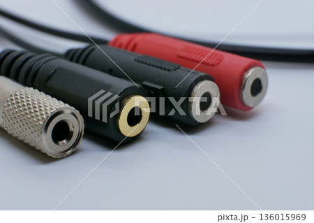 Close-up of audio jack adapters and connectors on a clean white background. Sound accessories for headphones, microphones, music devices, recording, and audio equipment Close-up of audio jack adapters and connectors on a clean white background. Sound accessories for headphones, microphones, music devices, recording, and audio equipment 136015969