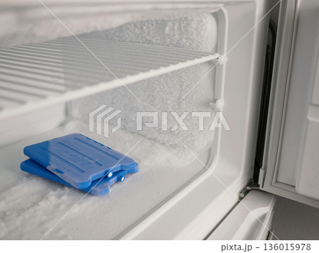 Icy Freezer Shelf with Ice Packs and Frost Buildup 136015978