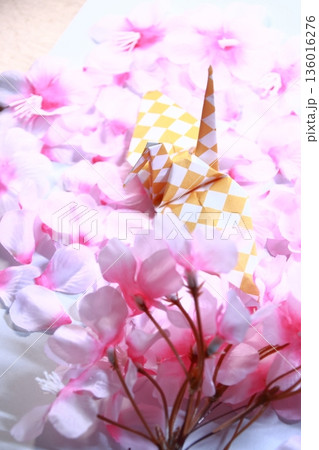春を感じさせる日本の伝統文化の折り鶴と桜の花びら(縦長) 春を感じさせる日本の伝統文化の折り鶴と桜の花びら(縦長) 136016276