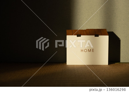 暗い部屋のHOMEと書かれた置物 光が家に当たっているイメージ 暗い部屋のHOMEと書かれた置物 光が家に当たっているイメージ 136016298