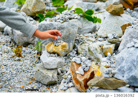 Relaxed spiritually child's hand arrangement pebble tower. Yoga relax meditation 136016392