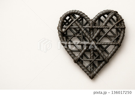 Woven metal heart on a light background. Space for text. 136017250