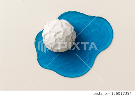 Crumpled paper ball on a blue spot. 136017354