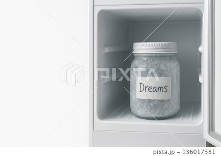 A jar with the inscription Dreams in a freezer on a white background. Space for text. 136017381