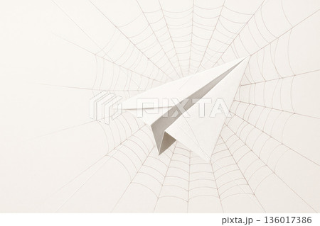 A paper airplane stuck in a spider's web is a metaphor for stalled ideas. Space for text. A paper airplane stuck in a spider's web is a metaphor for stalled ideas. Space for text. 136017386