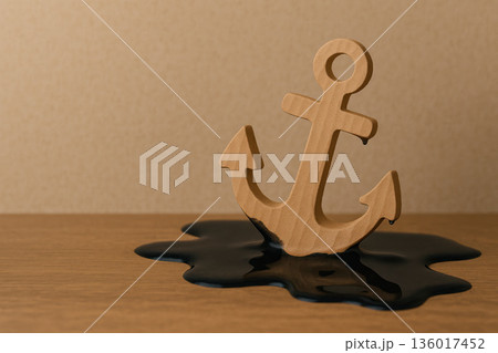 A wooden anchor is immersed in a black liquid. Space for text. A wooden anchor is immersed in a black liquid. Space for text. 136017452