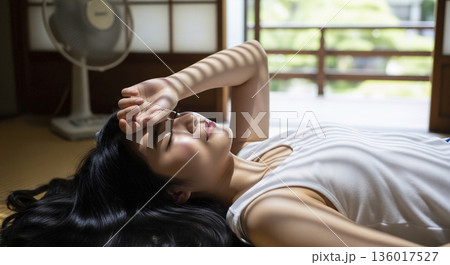 畳の部屋で横になって休む日本人女性 136017527