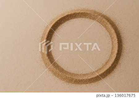 A circle of sand on a beige background. Space for text. 136017675