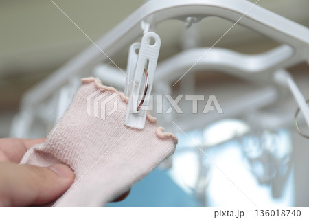 室内で靴下を干すママの手元 室内で靴下を干すママの手元 136018740