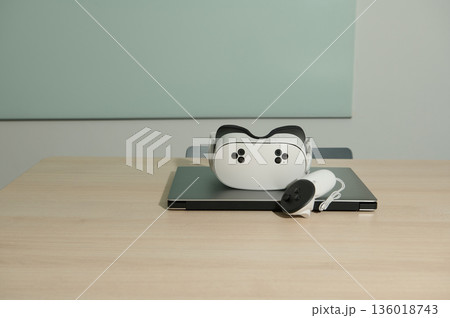 Virtual Reality Headset On Laptop With Controller On Desk 136018743