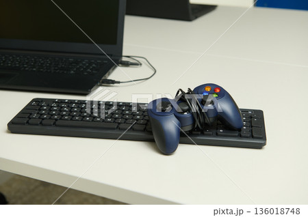 Gamer Setup With Controller On Keyboard And Laptop In Modern Office Desk Setting 136018748