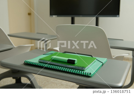 Classroom Desk With Green Notebooks And Marker In Front Of Presentation Screen 136018751