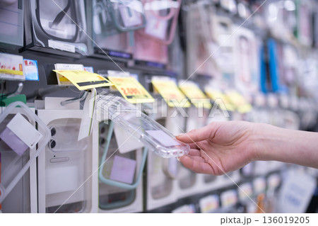 スマートフォンケースを選ぶ女性の手 136019205