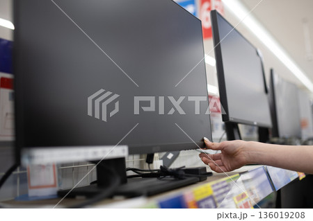 量販店でモニターを選ぶ女性の手 量販店でモニターを選ぶ女性の手 136019208