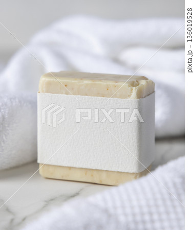 Mockup of beige solid soap bar with blank paper label near white bath towel, personal care packaging Mockup of beige solid soap bar with blank paper label near white bath towel, personal care packaging 136019528
