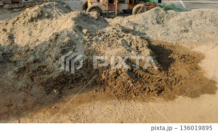 Construction site with piles of sand gravel and a vehicle Construction site with piles of sand gravel and a vehicle 136019895