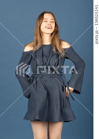 Young woman laughing in fashionable blue dress Young woman laughing in fashionable blue dress 136020141