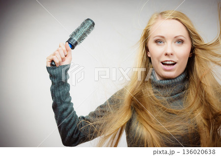 Girl styling her long hair Girl styling her long hair 136020638