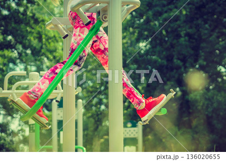 Girl doing legs exercises in outdoor gym Girl doing legs exercises in outdoor gym 136020655