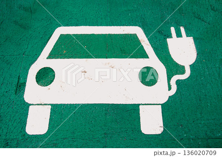Electric Vehicle Charging Symbol on Green Ground 136020709