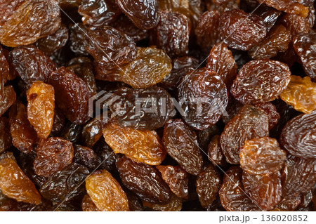Macro top view of dried grapes, sweet organic raisins. Macro top view of dried grapes, sweet organic raisins. 136020852
