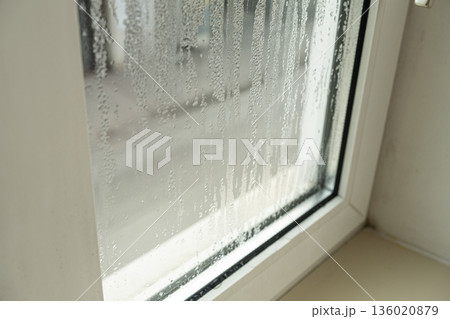 Close up of misted window glass with water streaks and droplets Close up of misted window glass with water streaks and droplets 136020879