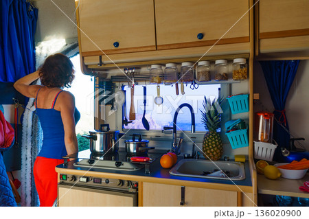 Woman inside Caravan, kitchen area 136020900