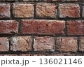 Brick wall. Close-up of a fresh brickwork. The red, hand-made uneven bricks, with visible clay layers and a rough texture, were neatly laid in cement mortar in South Asia. 136021146