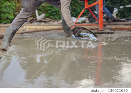 Construction Worker Smoothing Wet Concrete with Trowel 136021686