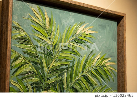 Textured oil paint on canvas showing green palm leaves in rustic wooden frame close up detail 136022463