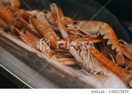 Fresh raw shrimps and oysters on display on ice at fishermen market. Seafood shop. Healthy food. Fish market showcase 136023654