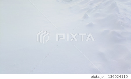 雪の起伏が連なる冬の雪原背景 136024110