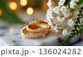 Elegant Gold Wedding Rings with Diamonds and Baby's Breath Flowers, Romantic Bokeh Background 136024282