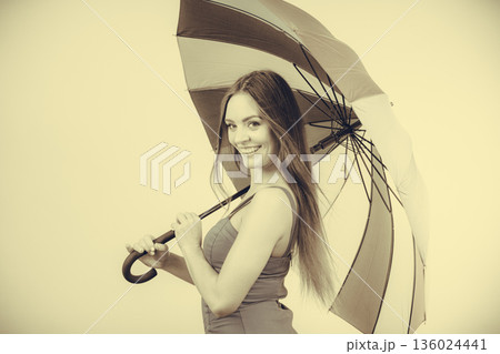 Woman in summer dress holds umbrella 136024441