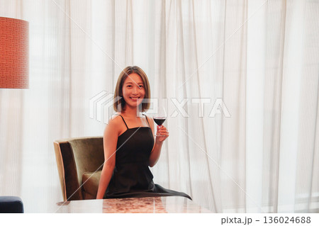 ホテルの客室でワインを楽しむ大人の女性 136024688