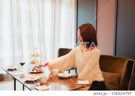 ワインをお客様におすすめをする女性のスタッフ 136024797