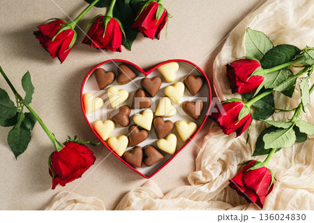 Valentine's Day background, heart gif box with heart chocolates and bouquet of red roses flowers. Mother's day concept Valentine's Day background, heart gif box with heart chocolates and bouquet of red roses flowers. Mother's day concept 136024830