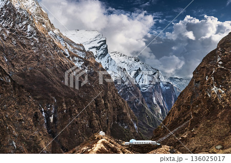 Snow capped steep cliffs in the Annapurna Sanctuary, Himalayan mountains in Nepal 136025017