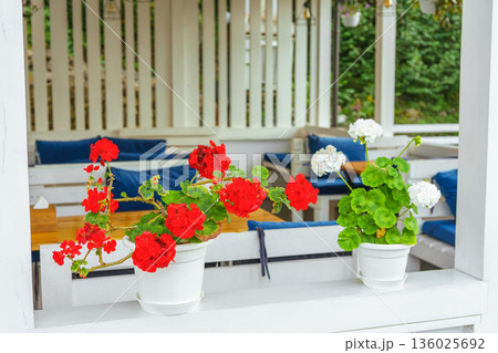 Outdoor cafe terrace with colorful decorative flowers in pots, cozy summer restaurant seating area 136025692