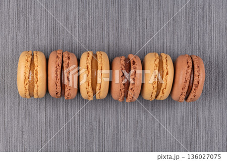 Six coffee and chocolated flavoured macaroons on vinyl background 136027075