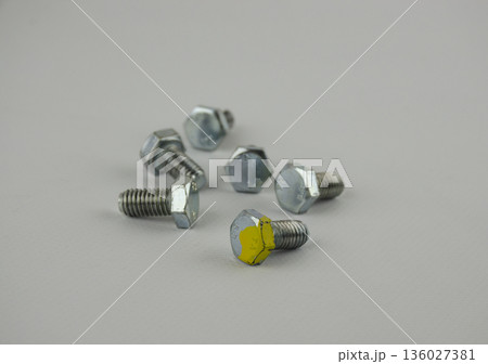 Hex head bolt screws thread on white background. One stand out of all 136027381