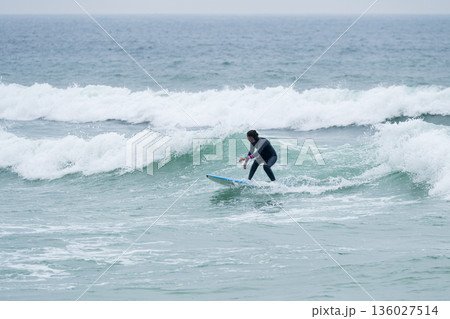 Surfer girl riding a wave Surfer girl riding a wave 136027514