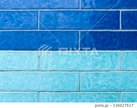 A textured wall showcases two distinct horizontal rows of rectangular tiles 136027617