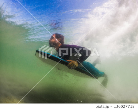 Bodyboarder duck diving a wave Bodyboarder duck diving a wave 136027718