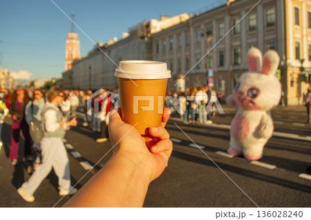Brown natural paper cup of drink against backdrop of road on Nevsky Prospekt in center of St. Petersburg Brown natural paper cup of drink against backdrop of road on Nevsky Prospekt in center of St. Petersburg 136028240