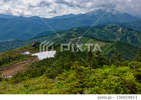 会津駒ヶ岳山頂直下から見る駒の小屋と燧ヶ岳 136028651