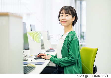 会社でデスクワークをするショートカットの若い女性社員 136029071
