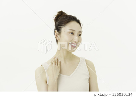 白背景のタンクトップを着て首筋を触る若い日本人女性 白背景のタンクトップを着て首筋を触る若い日本人女性 136030134